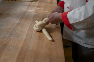 Hefezopf in der Bäckerei von Hand flechten