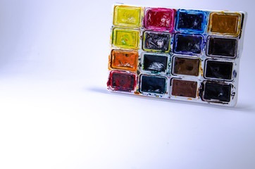 Palette with watercolors and brushes for paints on a white background. Watercolor paints. Brushes. Top and front view