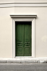 Fototapeta na wymiar A closed dark green wooden door. Entrance of a classic building.