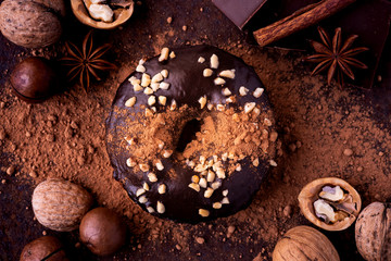 Chocolate donut with icing and nuts. Chocolate, cocoa, donut, walnut, star anise and cinnamon on a...