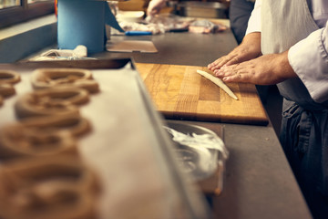 Obraz na płótnie Canvas the cook prepares the pretzels, oktoberfest Bake Bavarian Goodness