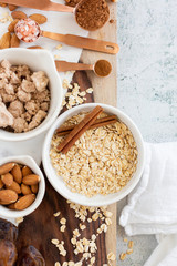 Ingredients for Brownie Balls with Oats, Raw Almonds, Cinnamon, Salt, Dates, and Cocoa on Cutting Board