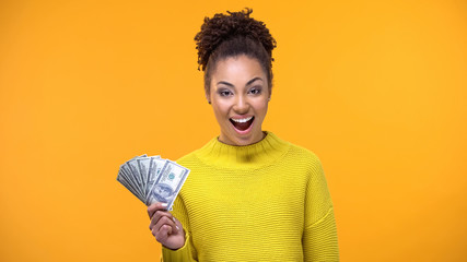 Happy African-American lady showing bunch of dollars on camera, high-paid job