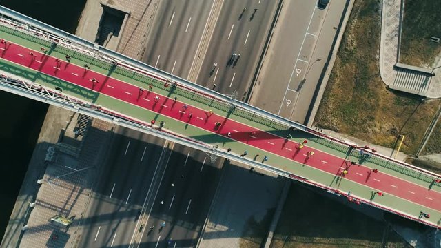 Marathon running on the footbridge and road. Top view spin shot