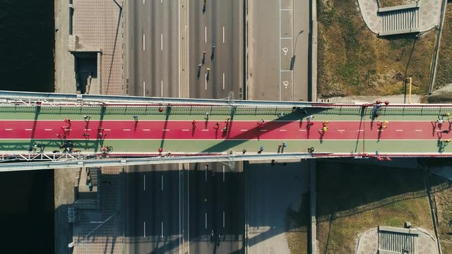 Marathon running on the footbridge and road. Top view shot