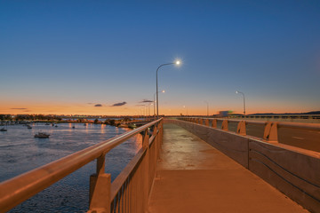 Fototapeta na wymiar Tauranga Harbour Bridge transport route with road and pedestrian and cycle path with glow of cyclists and vehicle passing lights