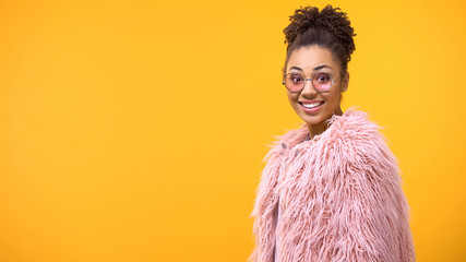 Excited young woman in pink eyeglasses looking camera, amazement, happiness