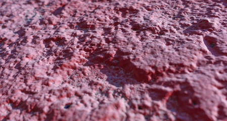 Concrete wall painted in red. Abstract background. Selective focus.
