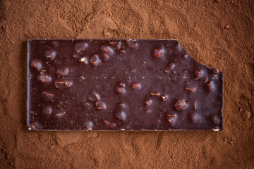 Dark chocolate and cocoa powder. Dark background, top view, copy space.
