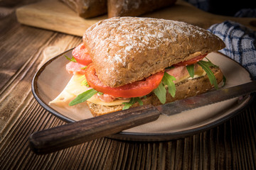 Triangular sandwich with cheese, ham and tomato.