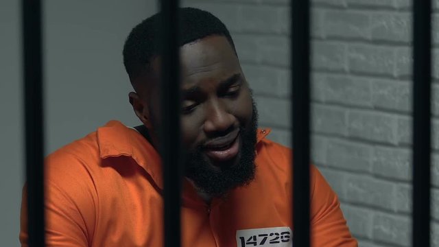Depressed African-American prisoner regretting about made crime, life mistake
