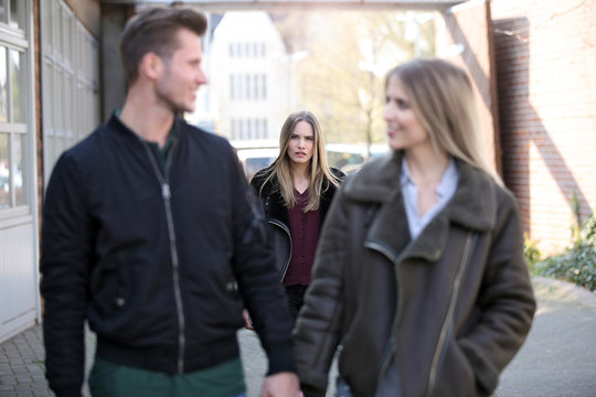 Junge Frau beobachtet eifers&uuml;chtig ein Paar