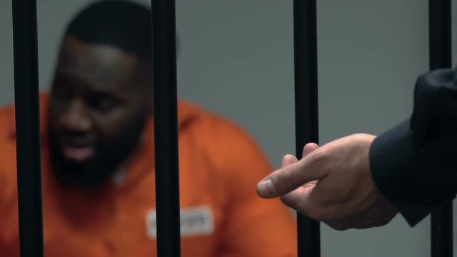 African-American prisoner looking on guard with baton in hands, punishment