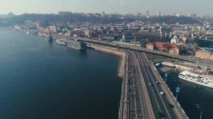 Marathon running on the bridge. City background. Wide shot