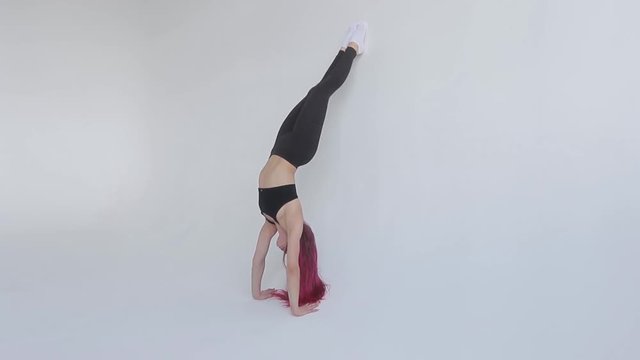 Fitness, stretching workout, attractive mature woman in violet sportswear working out in sports club, keeping fit, doing shoulderstand exercise, Viparita Karani, Upside-Down Seal pose in class.