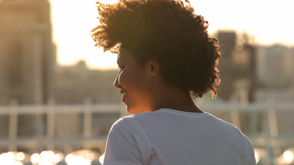 Excited african american woman enjoying morning sun outdoors, joy, back view