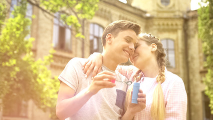 Fototapeta premium Sweet teenagers couple embracing, romantic date outdoors, having fun together