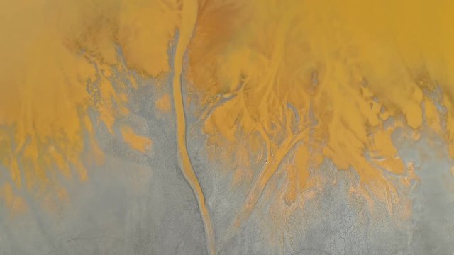 Toxic water flowing into sludge at a mining sterile disposal. Abstract patterns of merging textures