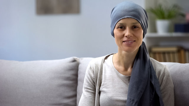 Woman recovering after chemotherapy looking at camera, survivor, background