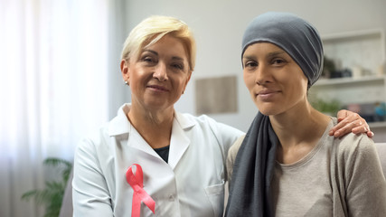 Woman with cancer and oncologist looking into camera, hope for healing, survival