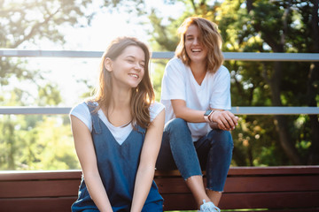 Two beautiful young woman resting on a bench