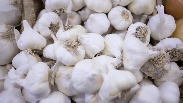 Slow motion of a pile of garlic at a farmers market