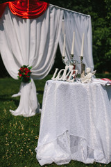 Table for the wedding ceremony of the bride and groom, decorated with letters of love, a statue of an angel, and a candlestick candelabrum.