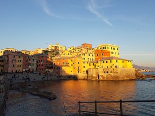 Genova, Italy - 04/15/2019: Boccadasse, a small sea district of Genoa, during the golden hour with some people enjoy the evening
