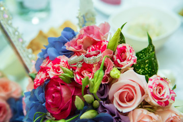 Wedding rings. Selective focus . Multicolored wedding gown.