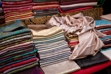 Thin beautiful handmade pashmina shawls lie on the counter