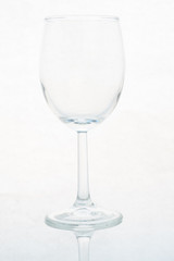 empty glass of wine on white background with reflection of legs