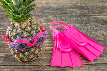 Pineapple with swimming glasses and flippers