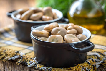 Broad beans served in black bowls.