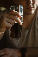 A glass of beer in a man's hand.