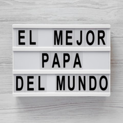 'El Mejor Papa Del Mundo' words on a lightbox over white wooden background, top view. Overhead, from above, flat lay.