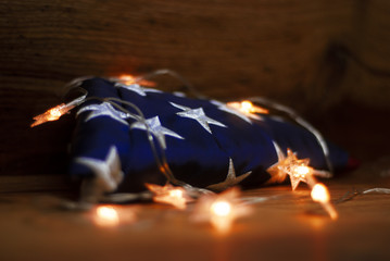 American flag with Garland on a wooden background for Memorial Day and other holidays of the United States of America.