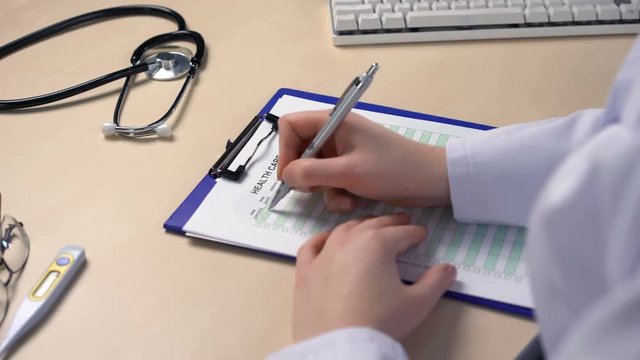 Doctor filling out health care costs form, calculating expenses, insurance forms. Healthcare and medicine