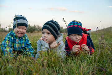 happy children playing in field sown with winter wheat against backdrop of rain clouds. Brothers have fun on vacation in village. Tradition of respect for nature, sports and harmonious life.