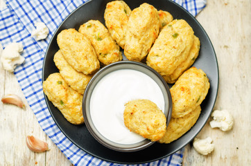 Baked cauliflower Tots on a wood background