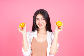 beauty woman Asian cute girl feel happy holdind orange fruit for good health  on pink background - lifestyle beauty woman