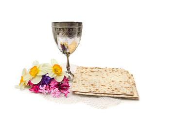 Matzo, wine, menorah and narcissus with hyacinths for passover celebration on white background with space for text