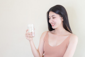 Beautiful beauty woman Asian cute girl feel happy drinking Clean drink water for good health in the morning , enjoying time in her home  white bedroom background - lifestyle beauty woman concept