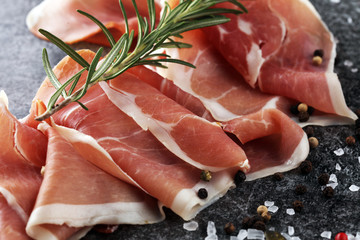 Italian prosciutto crudo or jamon with rosemary. Raw ham with spices