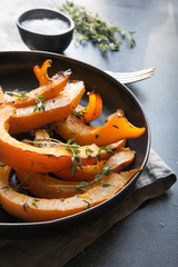 Roasted, baked pumpkin with addition aromatic thyme and salt. Healthy vegan food.
