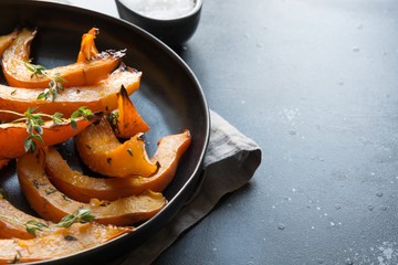Roasted, baked pumpkin with addition aromatic thyme and salt. Healthy vegan food.