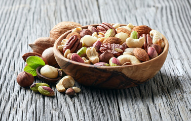 Fototapeta na wymiar Nuts in wooden plate in closeup