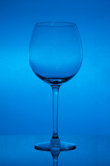 Empty wine glass on blue background, empty wineglass