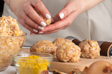 hands prepare meatballs from chicken meat