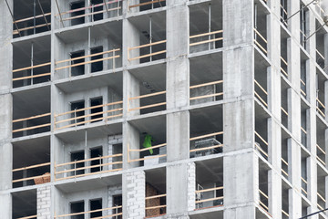 wall with window openings in a multi-storey high-rise residential building under construction from concrete and brick