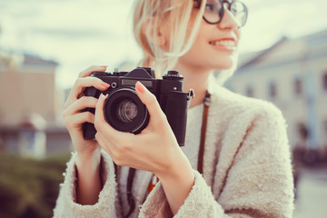 Beauty woman using vintage camera, make photo in the street, outdoor hipster portrait 